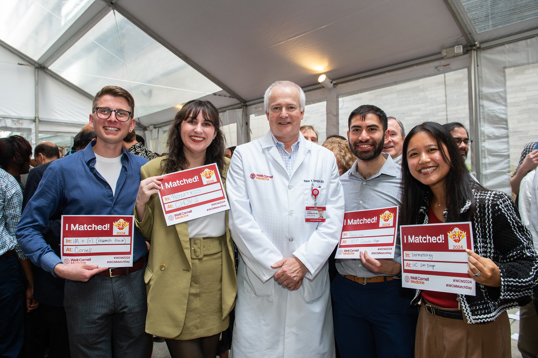 Dean Robert Harrington posing with students holding match signs