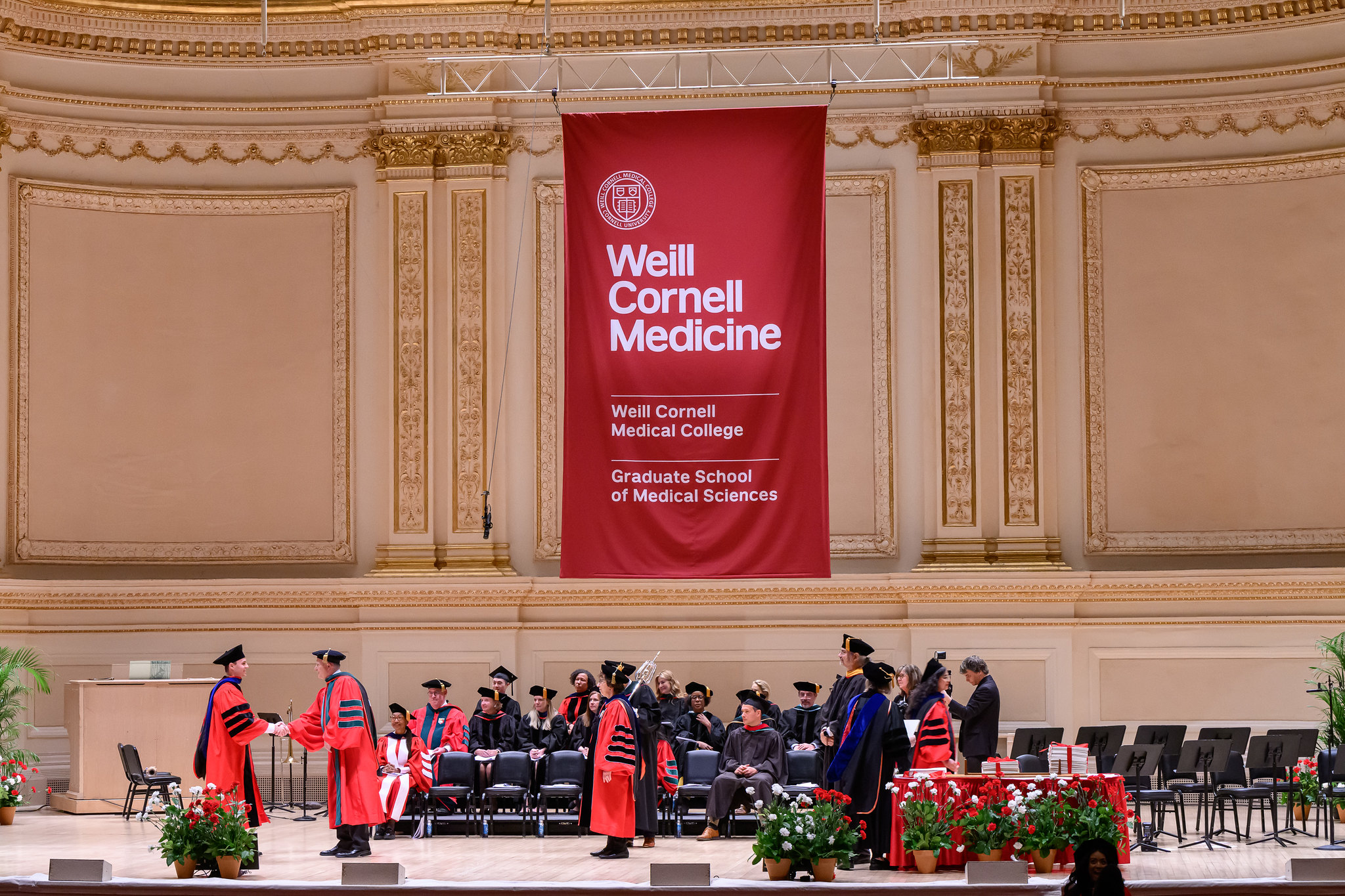Wide shot of Carnegie Hall Stage as student receives diploma 