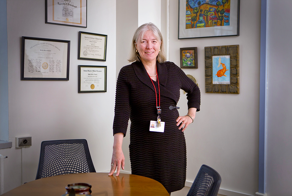 a woman standing posing for a photo in her office.