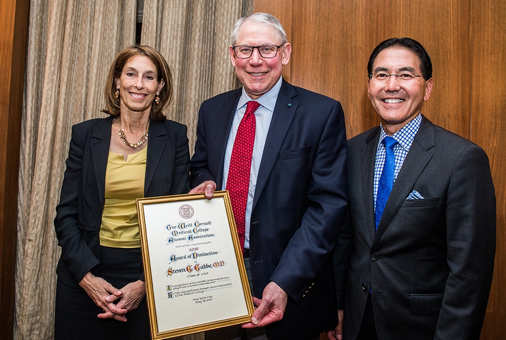 Dr. Steven Gabbe, center, accepts the Weill Cornell Medical College Alumni Association Award of Distinction from Dr. Laurie H. Glimcher and Dr. Spencer Kubo at an awards dinner on May 27. Photo Credit: Studio Brooke