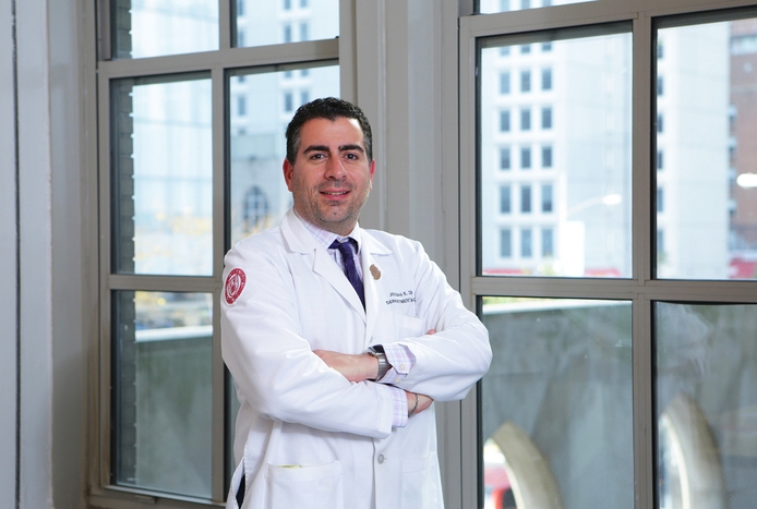 portrait of a man wearing a white coat in front of a window