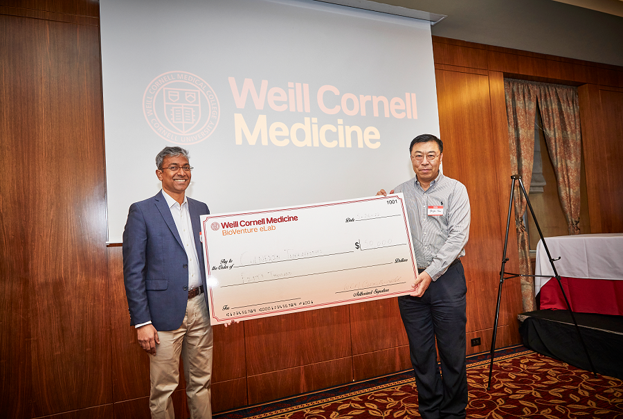 two men holding a large check