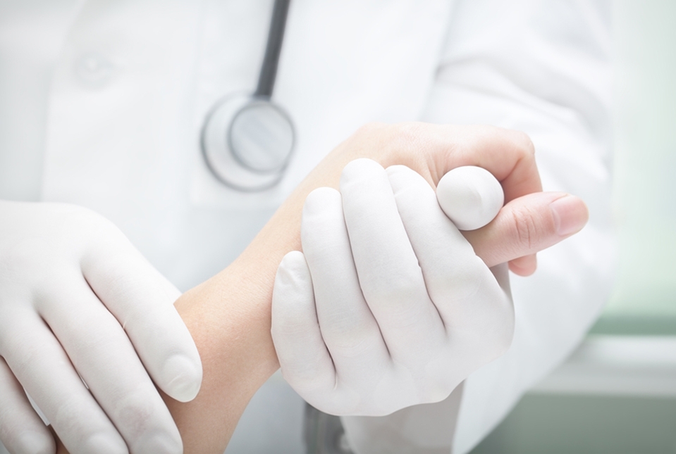 gloved doctor holding patient hand