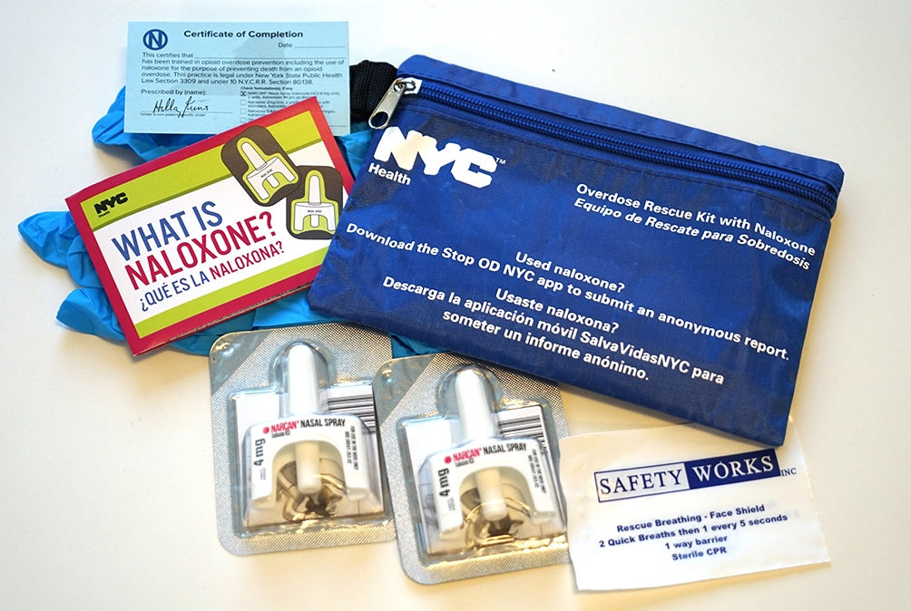 image of two naloxone nasal spray units, a blue NYC carrying case and an instruction packet