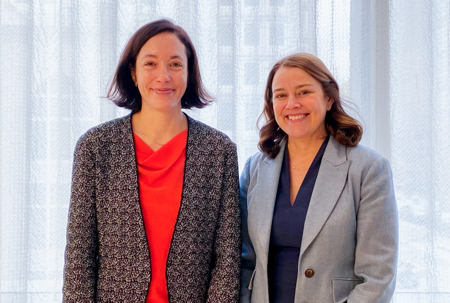 Two women standing next to each other in a room