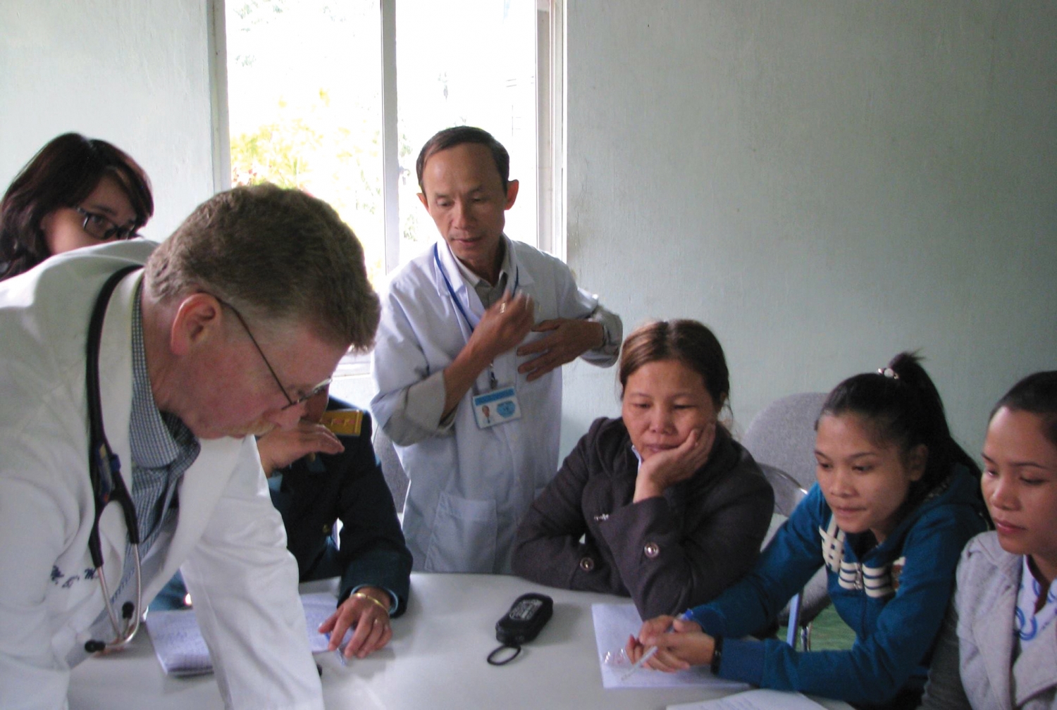 a group of nurses and a doctor working together at a table.