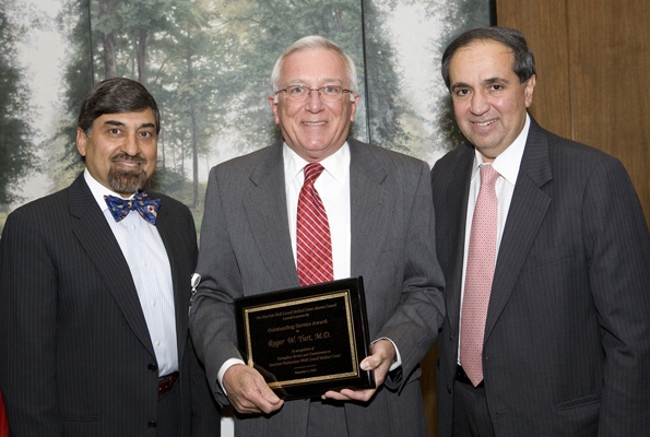 Dr. Roger Yurt is presented with the 2009 Outstanding Service Award by Dr. Frank Chervenak and Dr. Vinod Malhotra