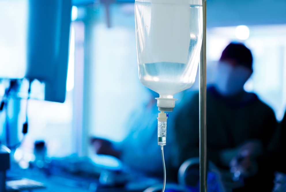 photo of IV drip bag and person in distance