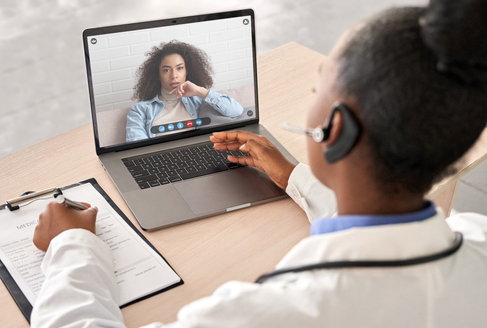 A doctor meets with a patient via telehealth