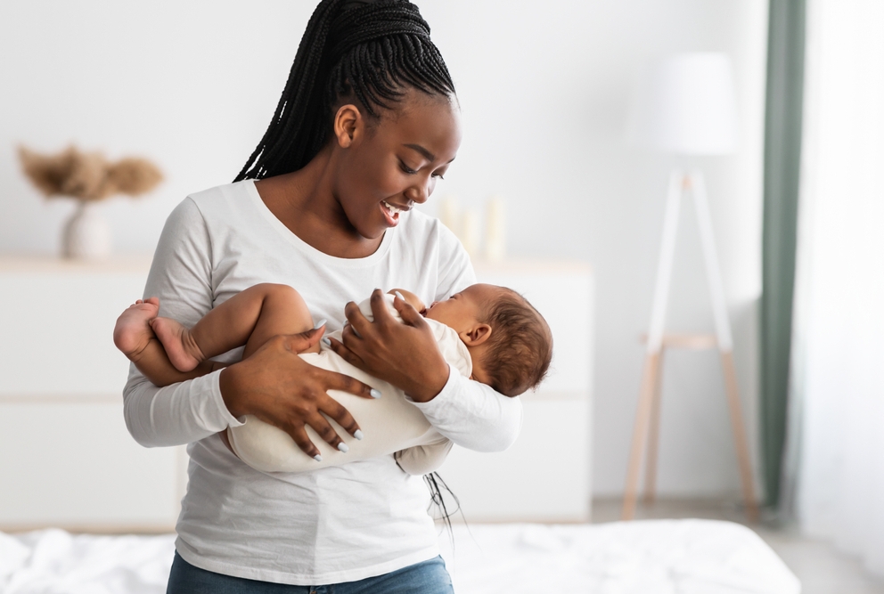 An African American woman holding her baby.