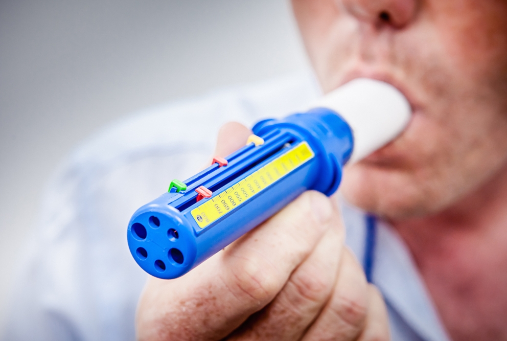 a person blowing into a peak flow meter