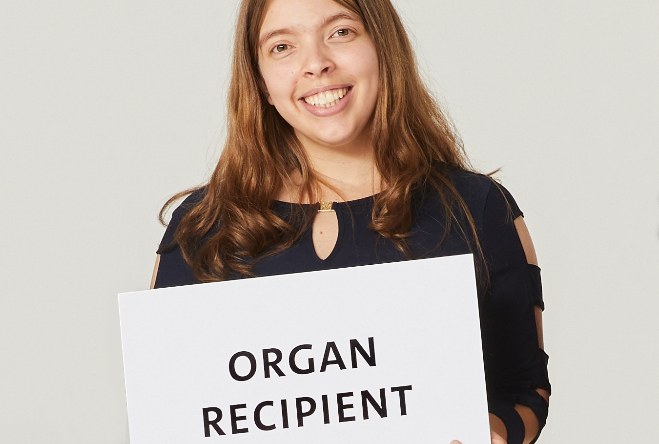 Woman holding an organ recipient card