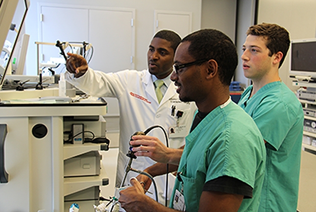 Dr. Anthony Watkins instructs Seth Aschen and Dawit Jowhar in laparoscopic techniques. 
