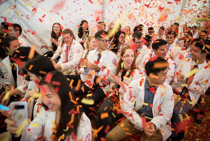 students at an event celebrating the while confetti flies around the room