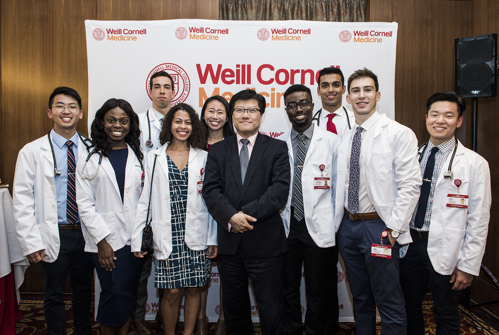 First-year medical students celebrate receiving their white coats with Dean Augustine M.K. Choi.
