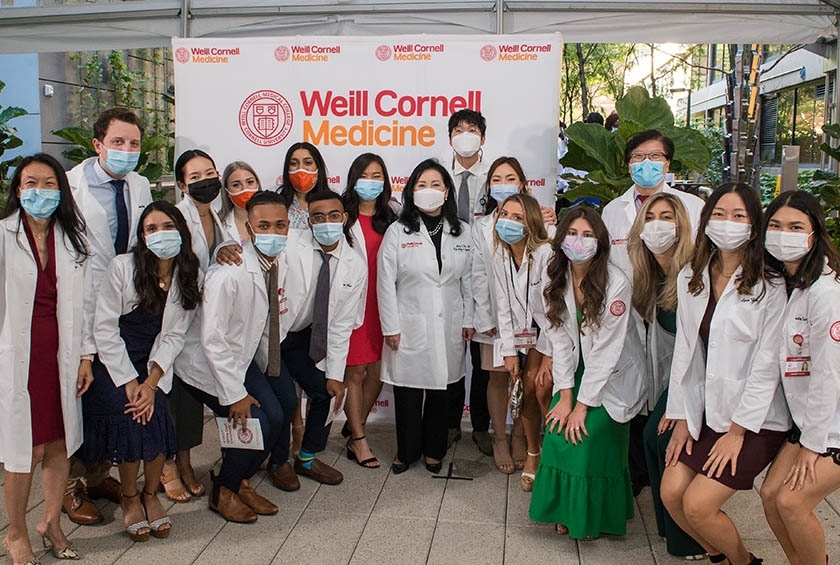 Students from the Class of 2024 pose with faculty during their White Coat Ceremony