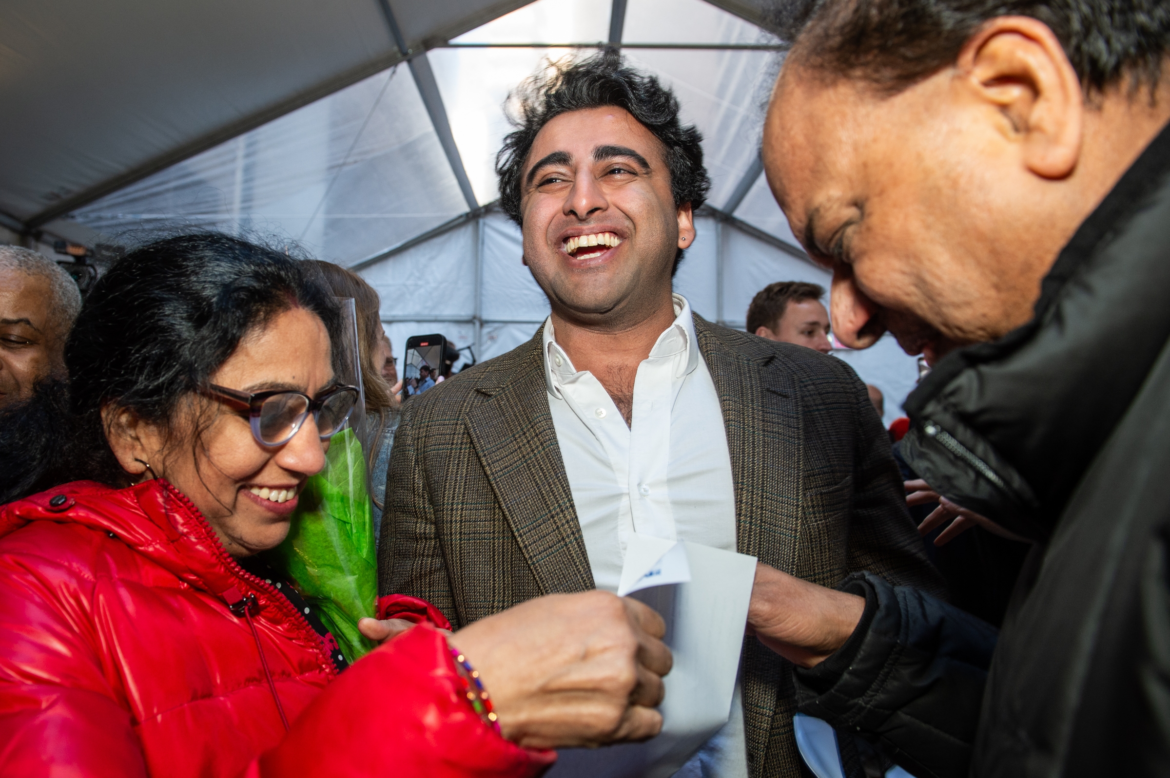 A man at an event, next to a man and woman