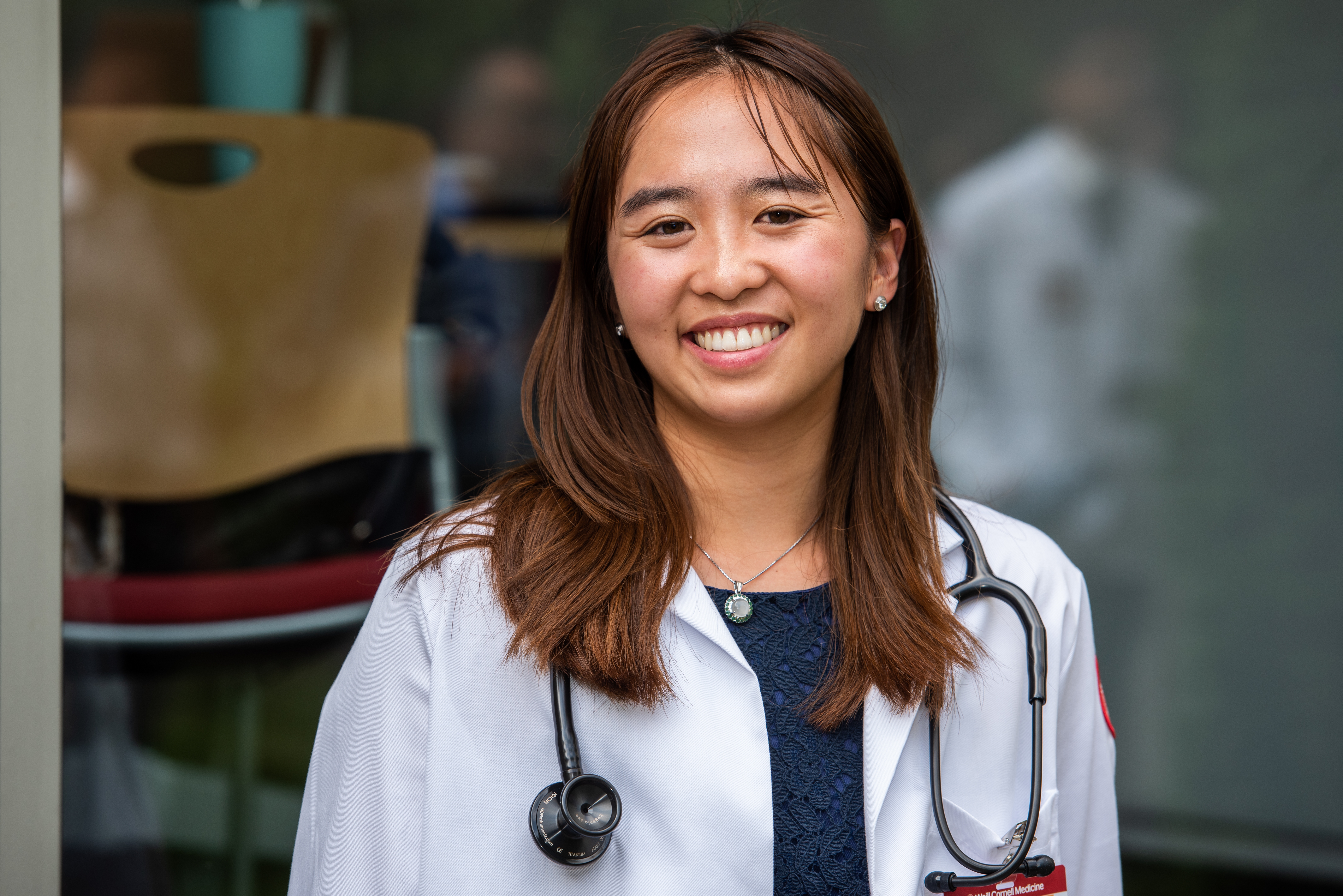 A female first-year medical student poses for a photo wearing her short white coat