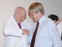 Dr. Ronald Crystal helps Peter Coombs into his white coat