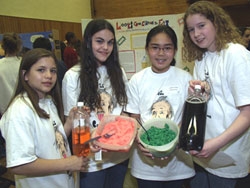 Seventh-grade students Elisa Shapiro, Veronica Morgenstern, Melissa Rusli and Mary-Catherine Craig with their exhibit, "Looks Good Enough to Eat," at the science competition held on April 25. Their exhibit won the award for the Most Creative category. (Ke