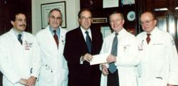 Richard Rose, president of the Cancer Research and Treatment Fund, presents a check for $400,000 to Dean Antonio Gotto