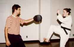 student and Tae Kwon Do club member Tomas Fernandez-Alfonso watches Dr. Carrie Bromleigh practice a kick.