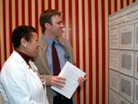 Medical student John Peoples discusses his poster exhibit "Cytokine Expression in Neonatal Cord Blood in Response to Lactobacillus Plantarum, Lp299v and Staphylococcus Epidermis (S.epi)," with Dr. Carol Storey-Johnson.