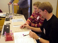 Teachers apply reagents to ELISA wells to determine the HIV status of two patient "blood samples."