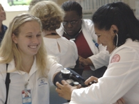 Blake Selby, a nurse, has her blood pressure taken by student Yael Leal.