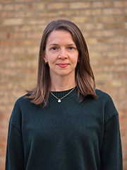 Head of a woman in front of a brick wall