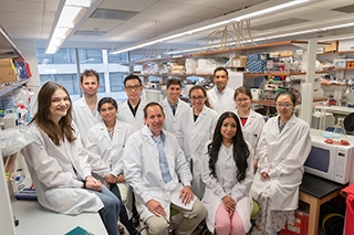 picture of Greg Sonnenberg and his lab members sitting in the lab
