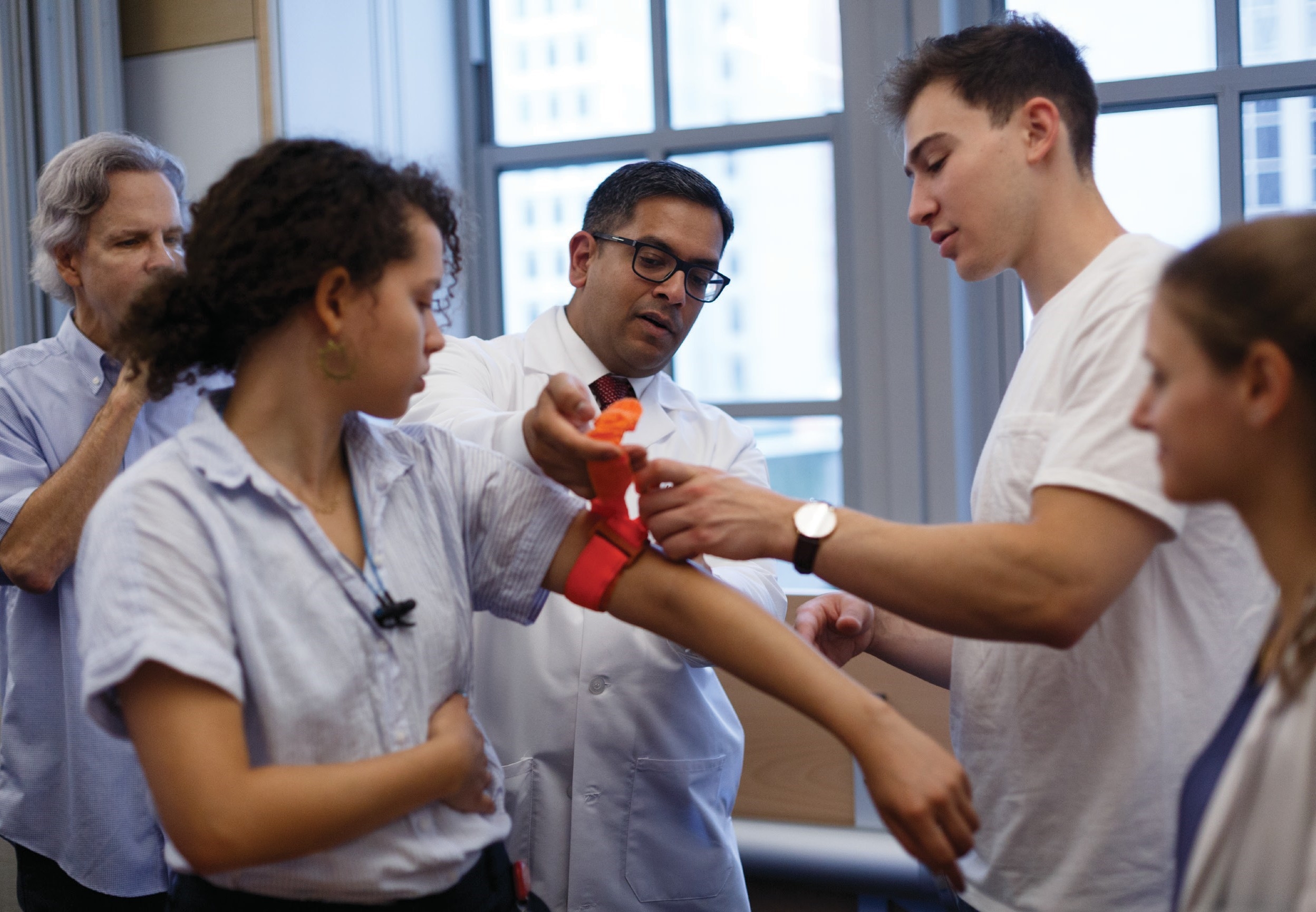 doctor teaching students how to stop someone from bleeding out