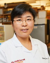 a woman posing for a photo in a lab coat