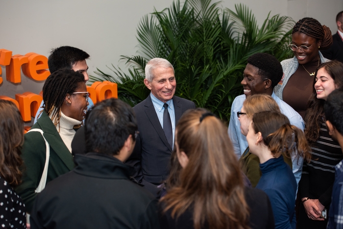 students gathered around Dr. Anthony Fauci following his documentary screening at a medical institution