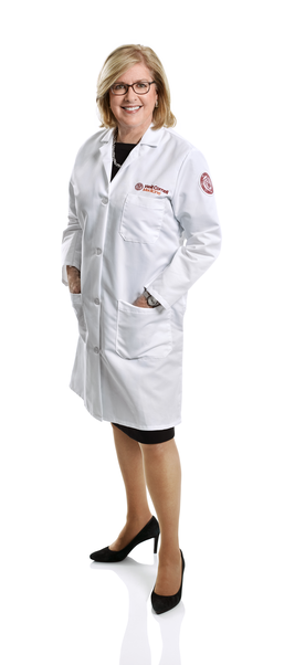 a woman in a white coat smiling