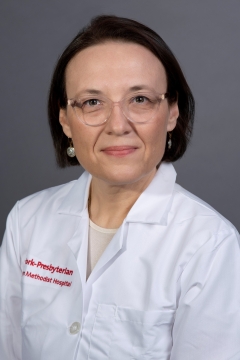 A woman with glasses smiling for a portrait