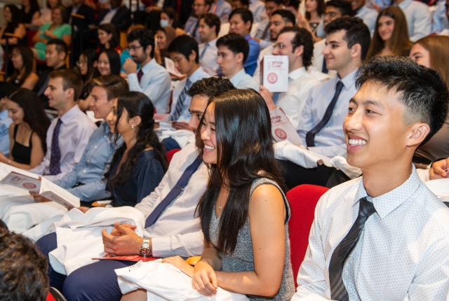 students smiling while seated in the audience 