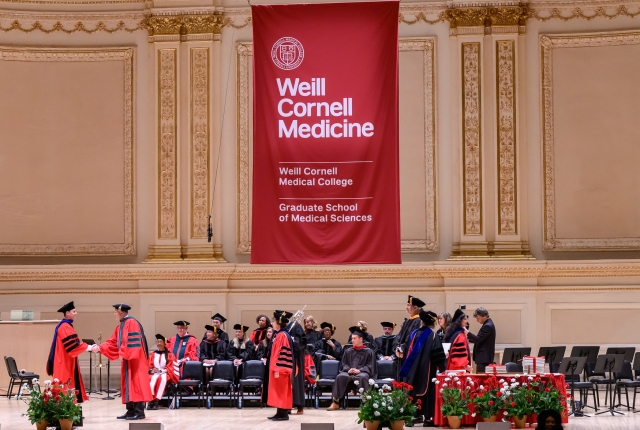 Wide shot of Carnegie Hall Stage as student receives diploma 