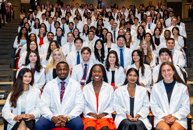 Group photo of students in white coats 